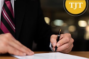 Man in a suit signing a court document, representing the dismissal order that starts the six-month waiting period for PTI or conditional discharge expungement in Morris County, New Jersey